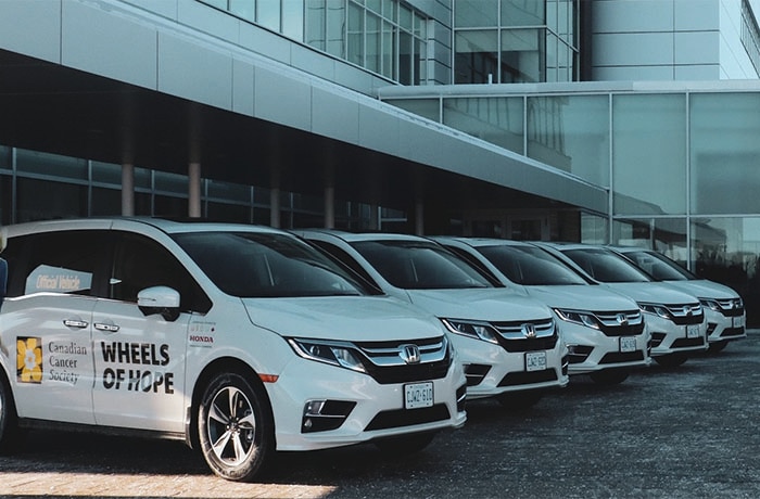 Une rangée de Honda Odyssey blanches données au service Roues de l’espoir de la Société canadienne du cancer.
